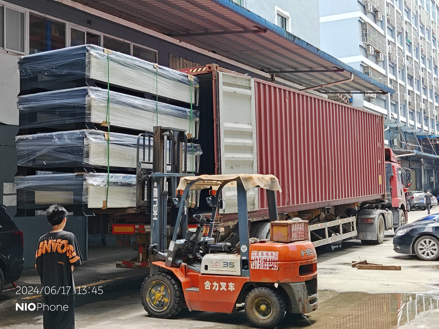 Wrapped equipment being moved into a shipping container by forklift